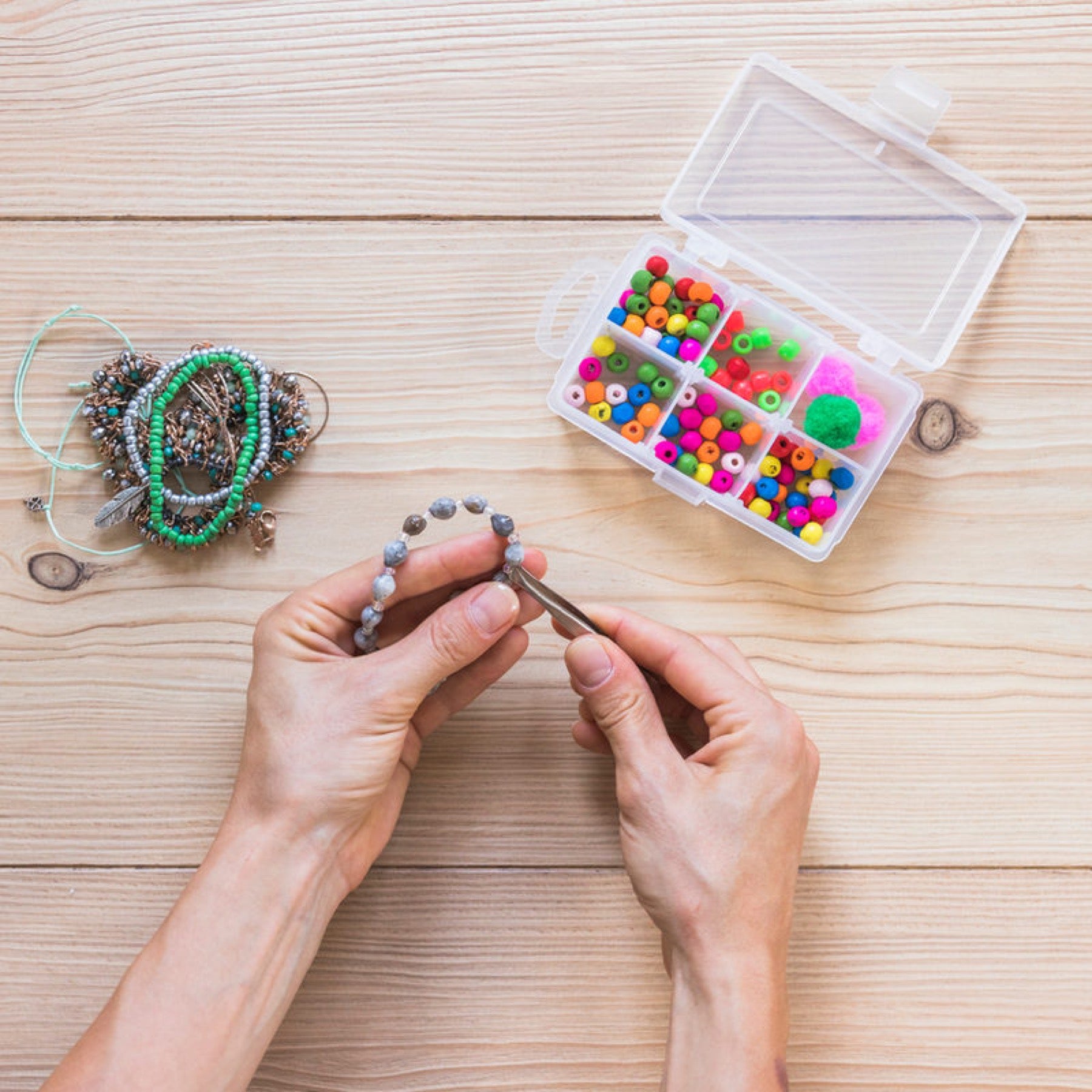 Manos tejiendo una pulsera